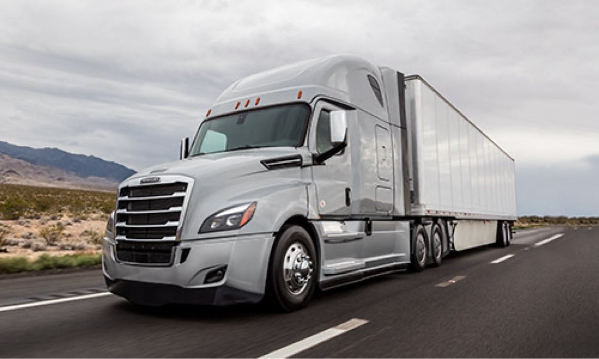 Silver Freightliner Cascadia pulling a white 53-foot trailer on a desert interstate